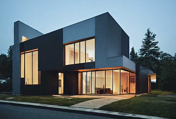 Modern two-story house with large windows and minimalist design.