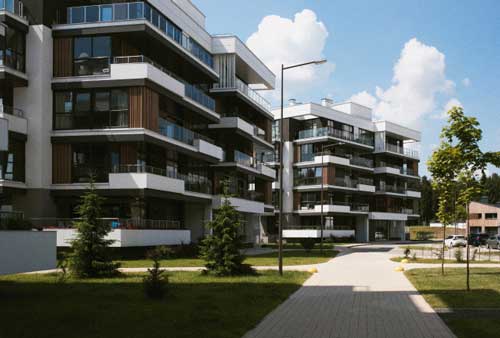 Modern residential apartment buildings with balconies and landscaped surroundings.